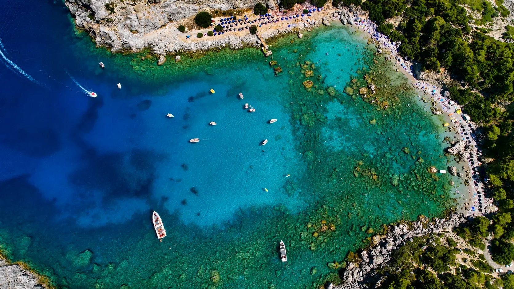 Overhead aerial view of Anthony Quinn Bay and clear emerald water